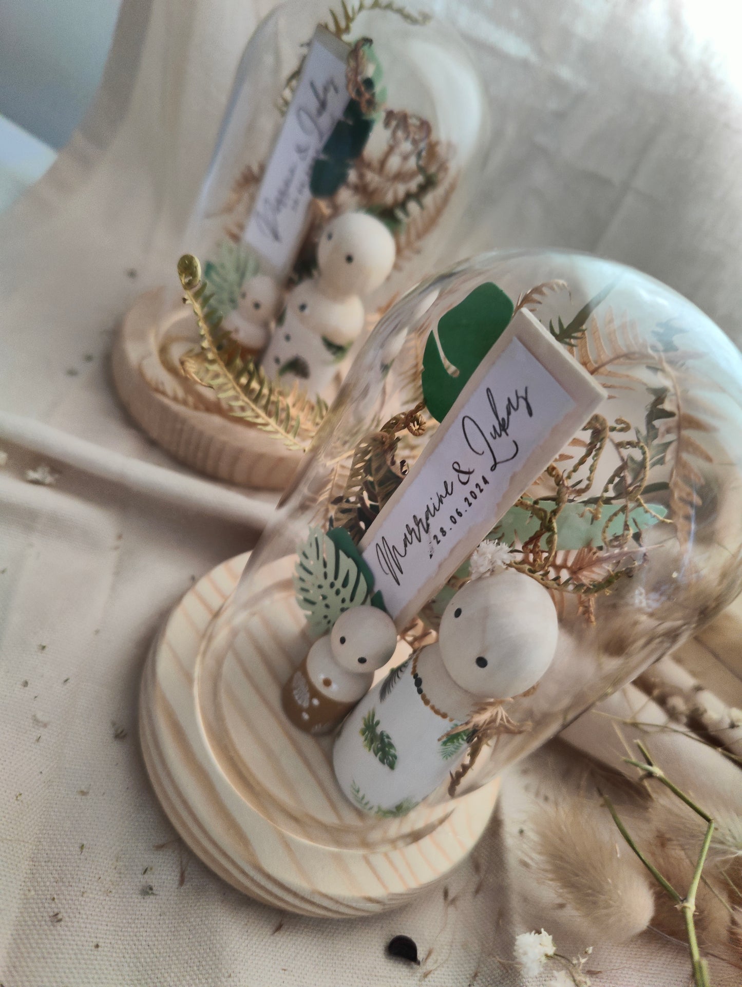 alt="Figurines en bois sous mini cloche en verre décor jungle – souvenir artisanal SoElya"