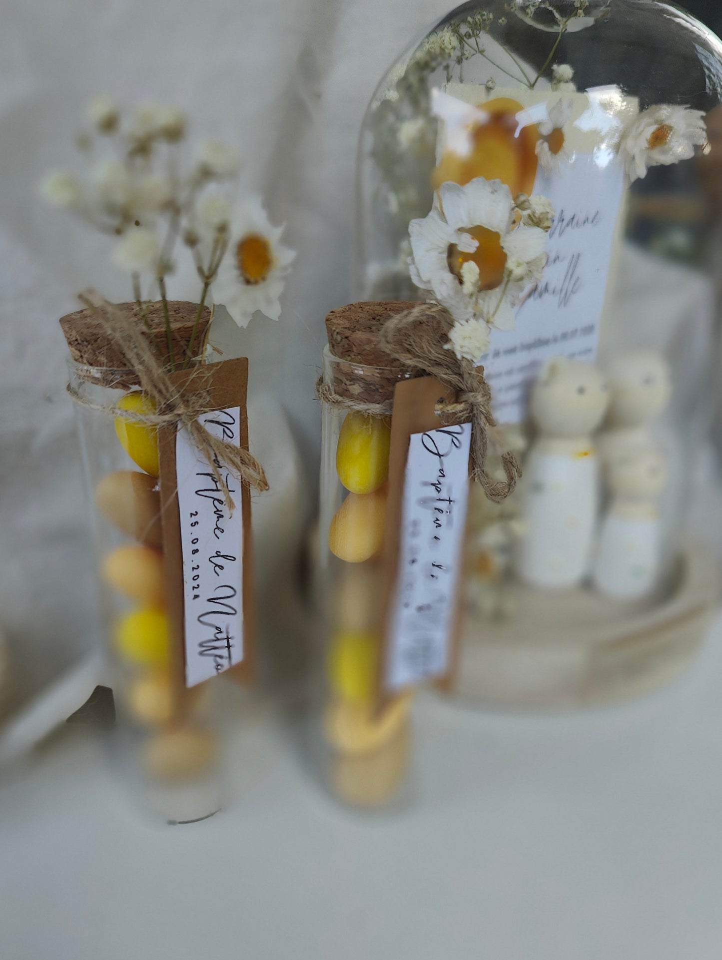 alt="Figurines en bois sous mini cloche en verre Marguerites – souvenir floral délicat"