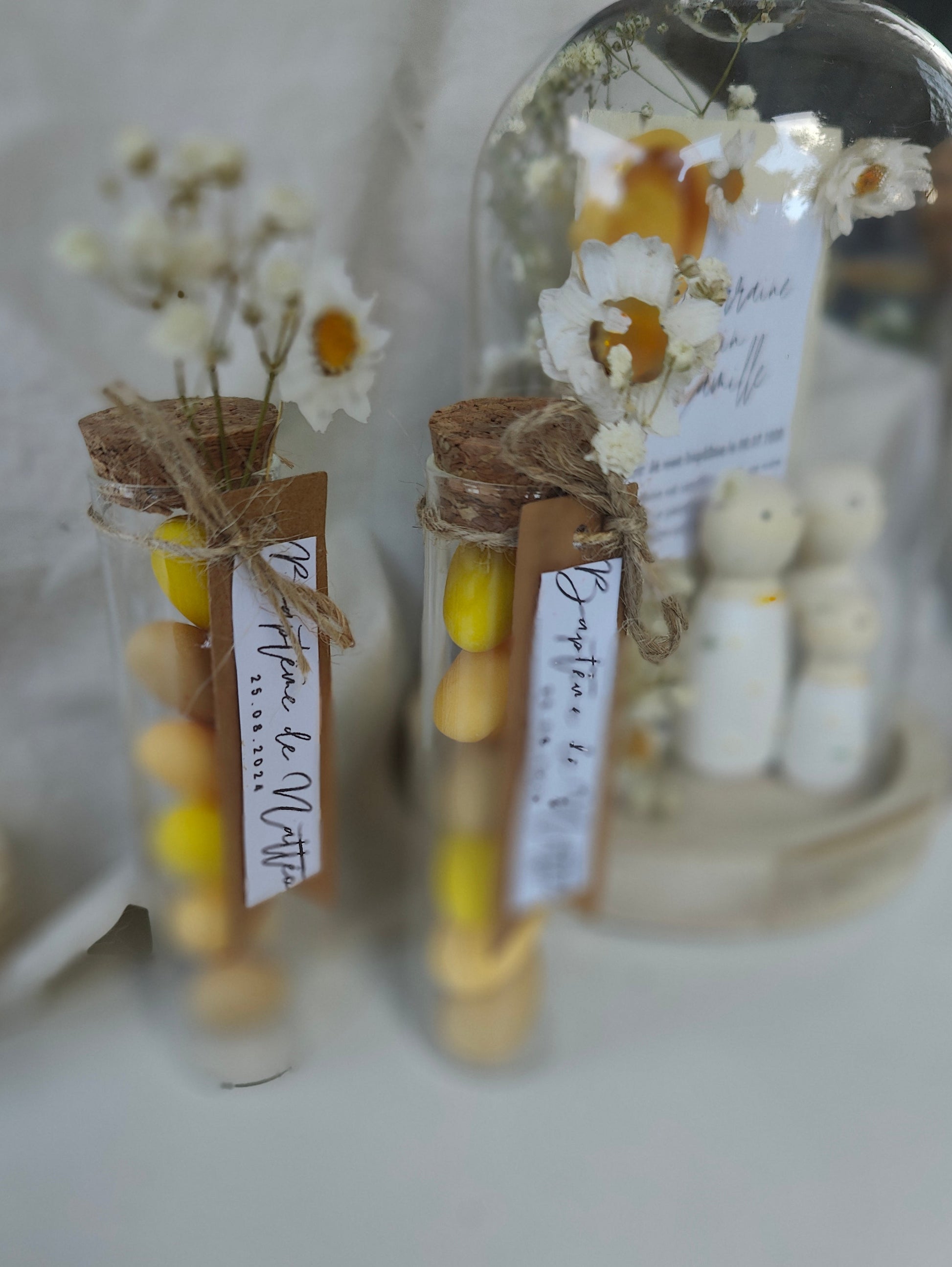 alt="Figurines en bois sous mini cloche en verre Marguerites – souvenir floral délicat"